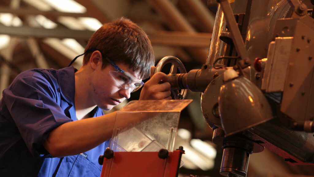 A young adult working on a mechanical machine